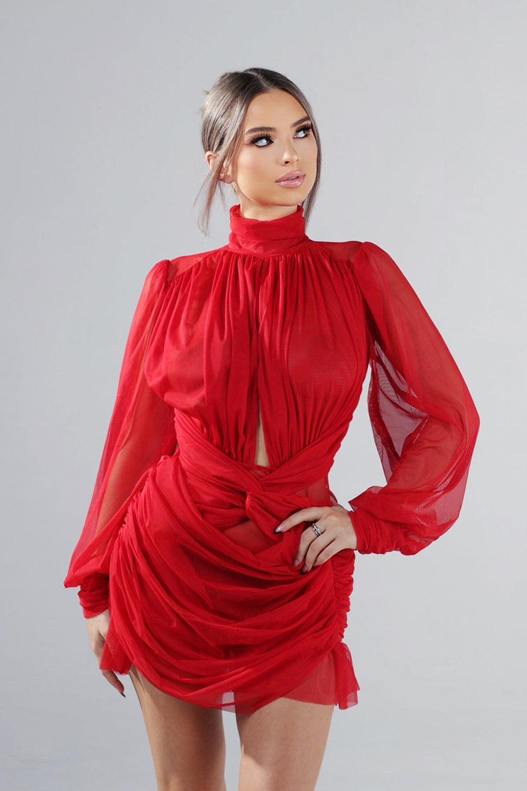 Long sleeve sheer mesh mini dress with mock neckline featuring keyhole front and twist waist cutout detail