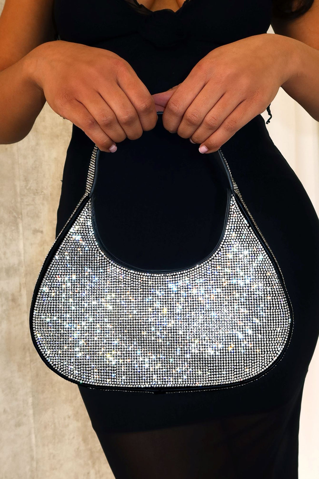 EDGE — black rhinestone-embellished shoulder bag held by a model in a black dress