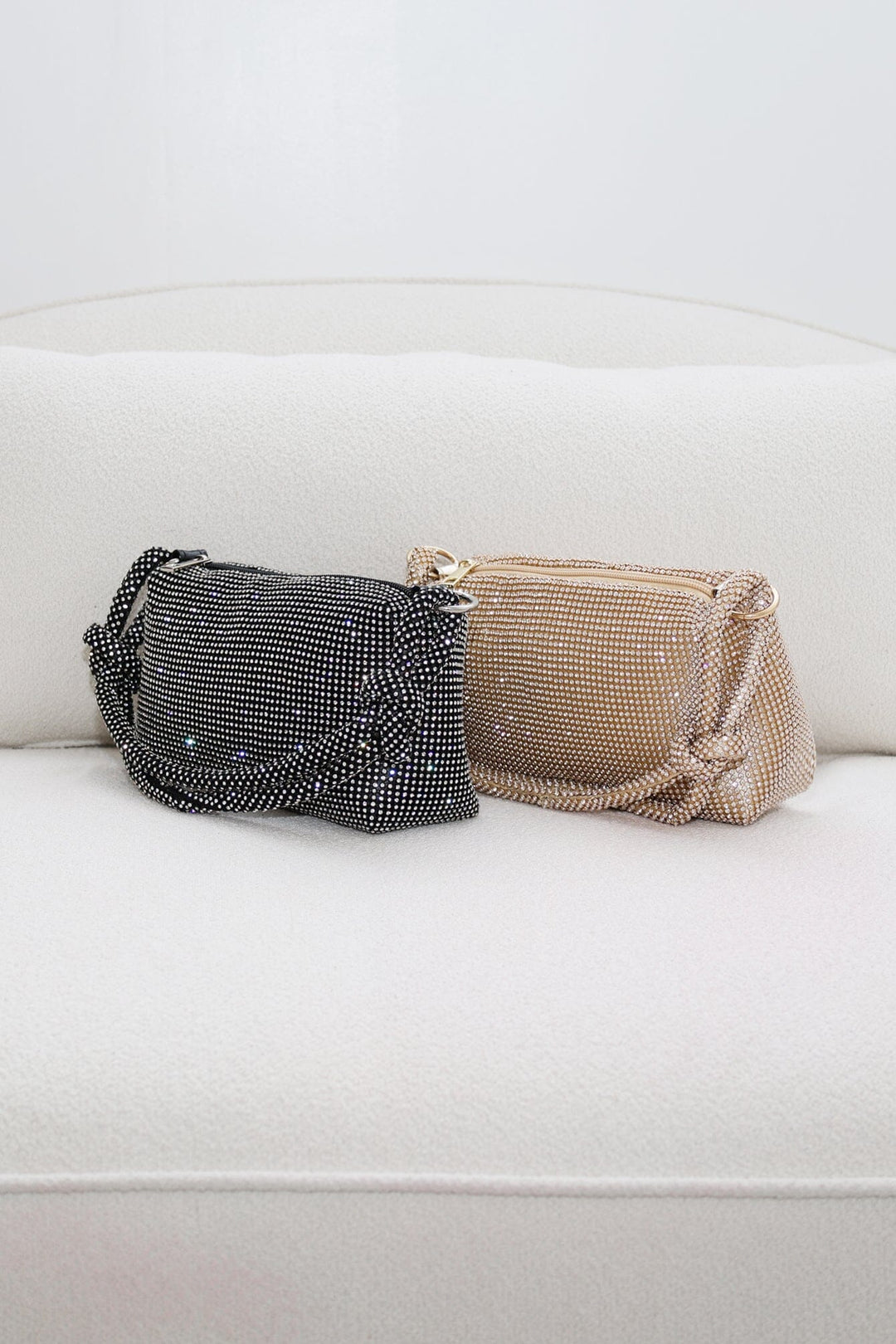 EDGE — black and gold rhinestone-embellished top handle evening bags shown side by side