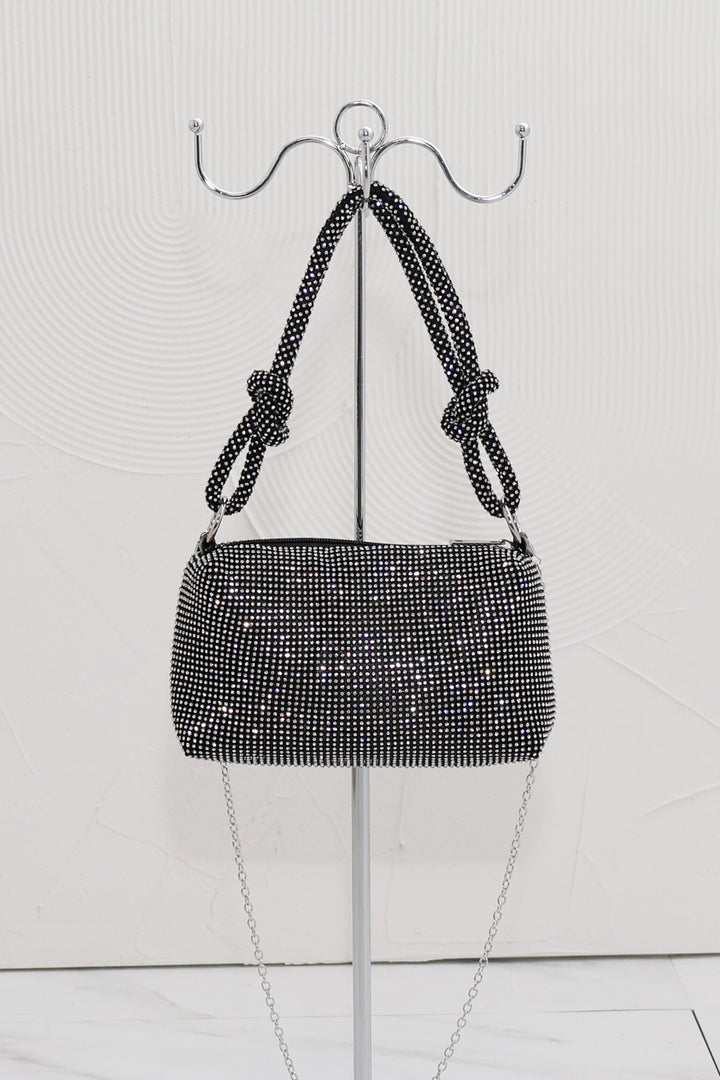 EDGE — black rhinestone-embellished top handle evening bag displayed on a stand