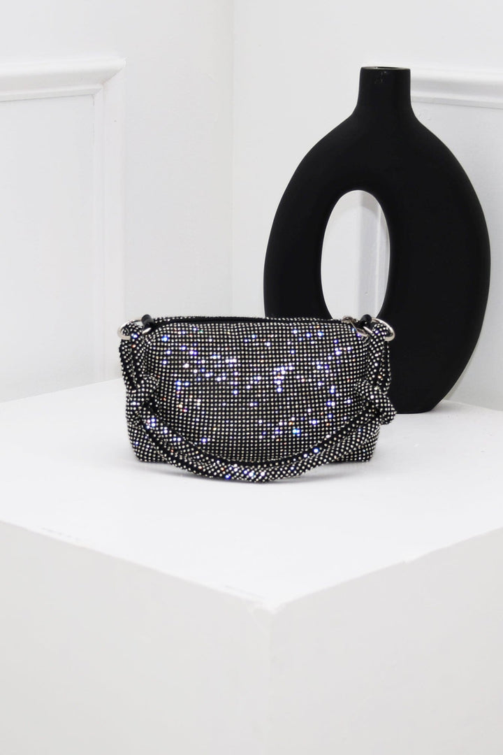 EDGE — black rhinestone-embellished top handle evening bag styled on a pedestal