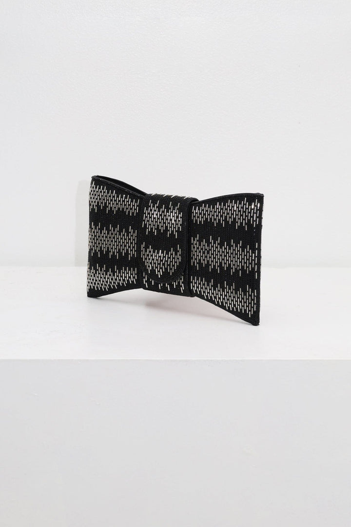 EDGE — black rhinestone bow-shaped evening clutch, angled view flat lay