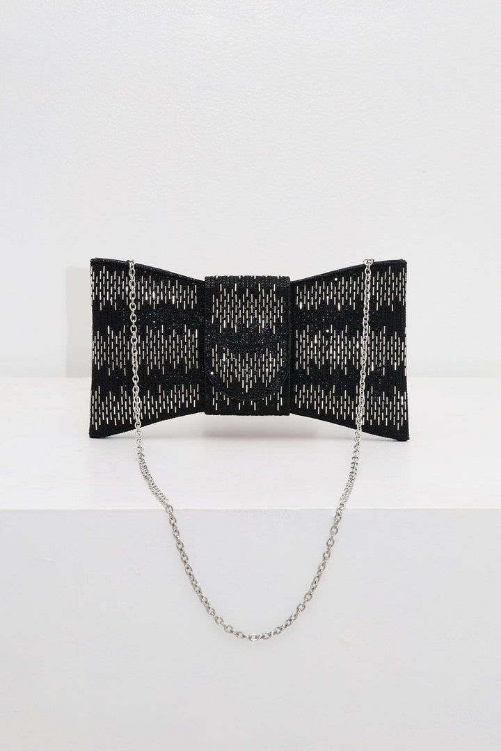 EDGE — black rhinestone bow-shaped evening clutch with chain strap, flat lay
