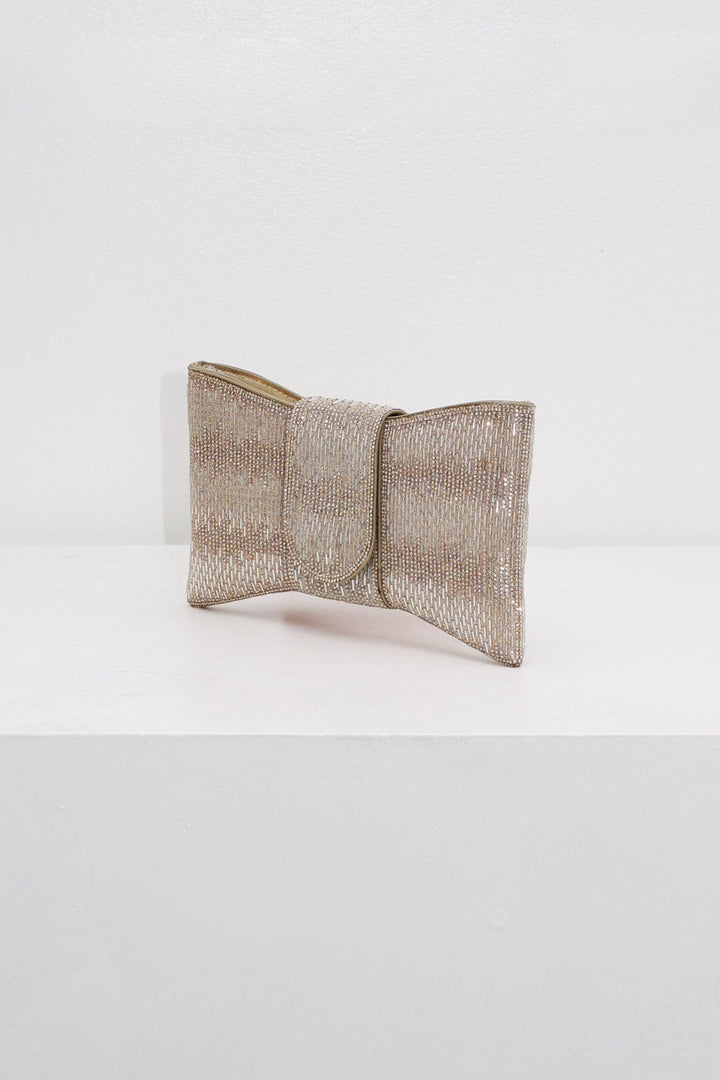 EDGE — gold rhinestone bow-shaped evening clutch, angled view flat lay