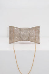 EDGE — gold rhinestone bow-shaped evening clutch with chain strap, flat lay