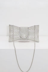 EDGE — silver rhinestone bow-shaped evening clutch with chain strap, flat lay