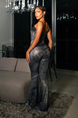 Strapless fitted crop tube top in a glossy crocodile embossed print with asymmetrical draped hem crossing at the front