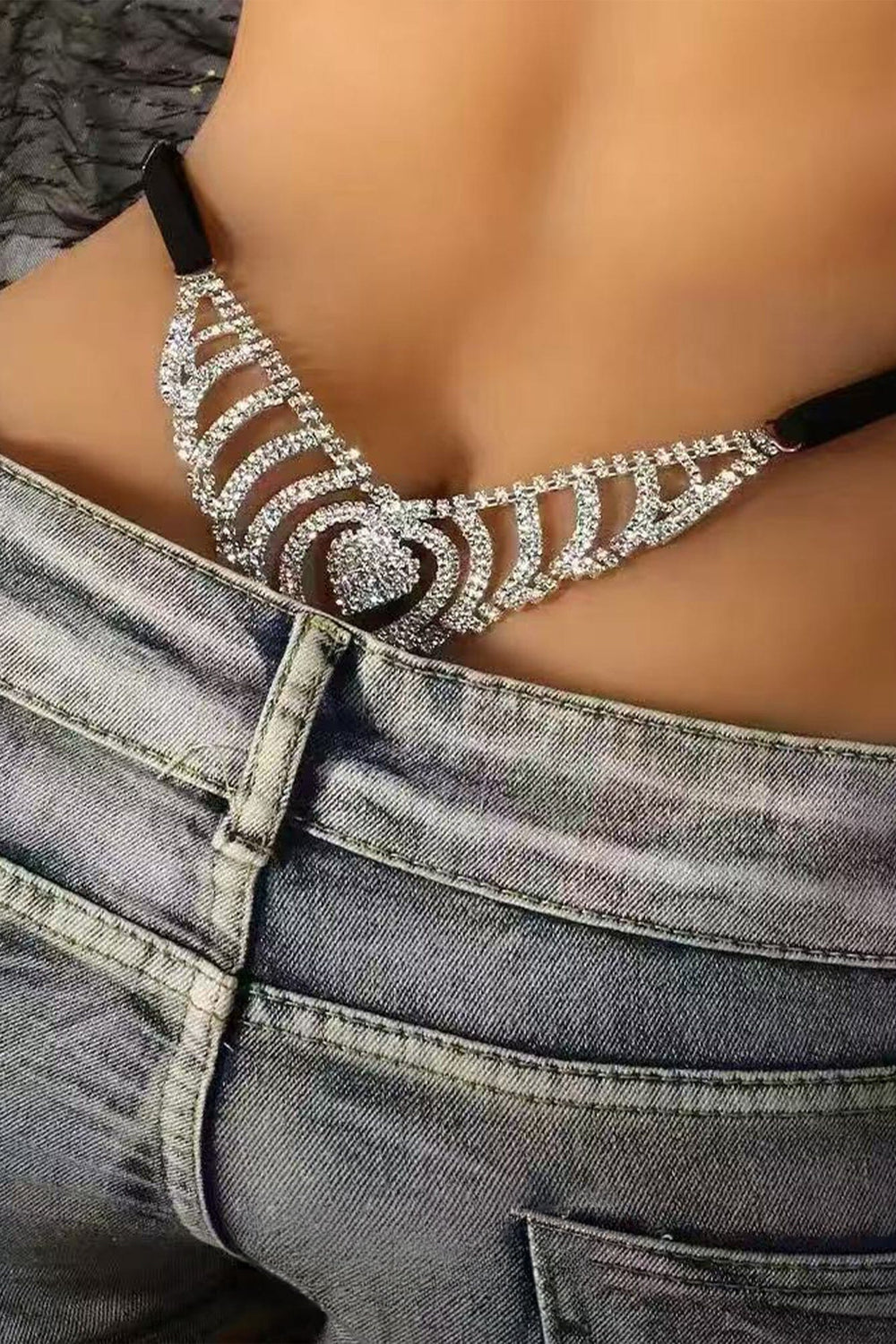 Black rhinestone body thong chain with heart-shaped centerpiece, close-up on model