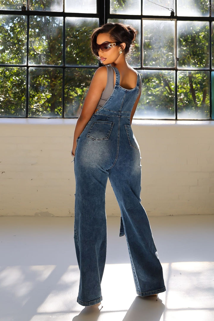 Denim wide leg overall jumpsuit featuring adjustable straps and snap pockets