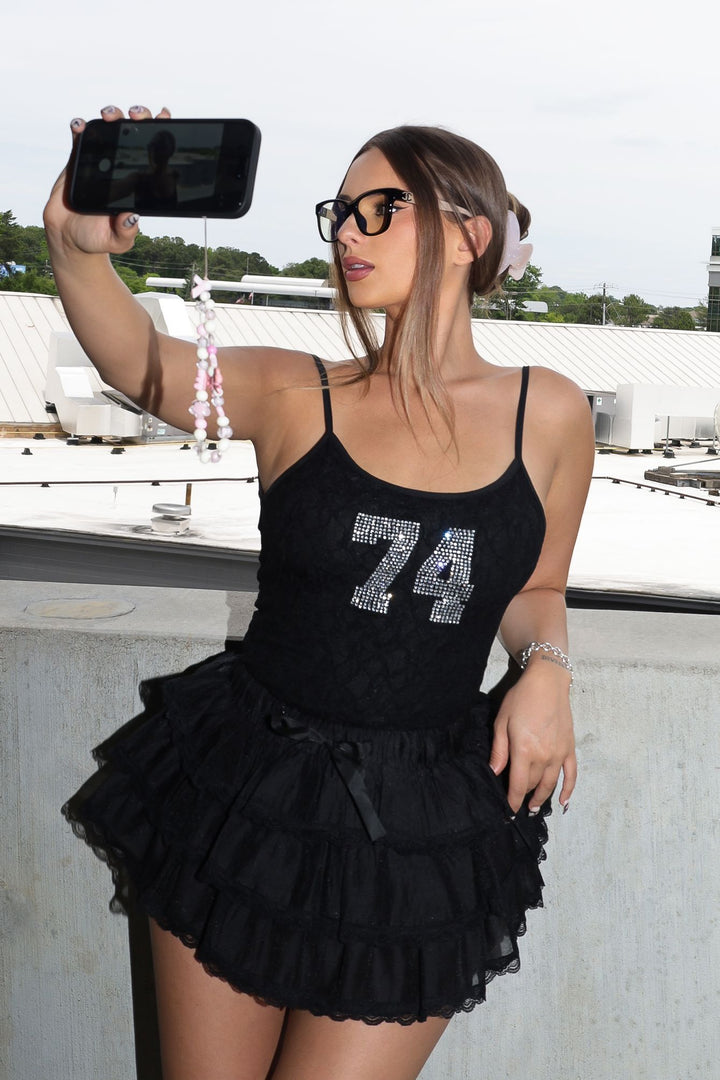 Low rise mini skort featuring ruffle lace trim and ribbon ties at the front