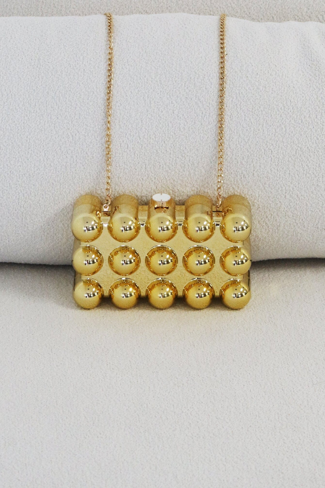 EDGE — gold bubble-textured mini clutch, close-up front view flat lay