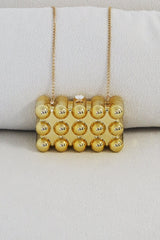 EDGE — gold bubble-textured mini clutch, close-up front view flat lay