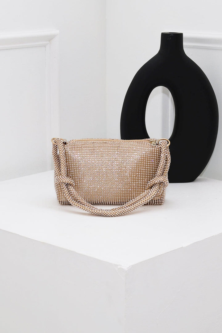 EDGE — gold rhinestone-embellished top handle evening bag styled on a pedestal