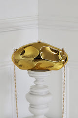 EDGE — gold mirror-plated mini clutch displayed on a pedestal, front view flat lay