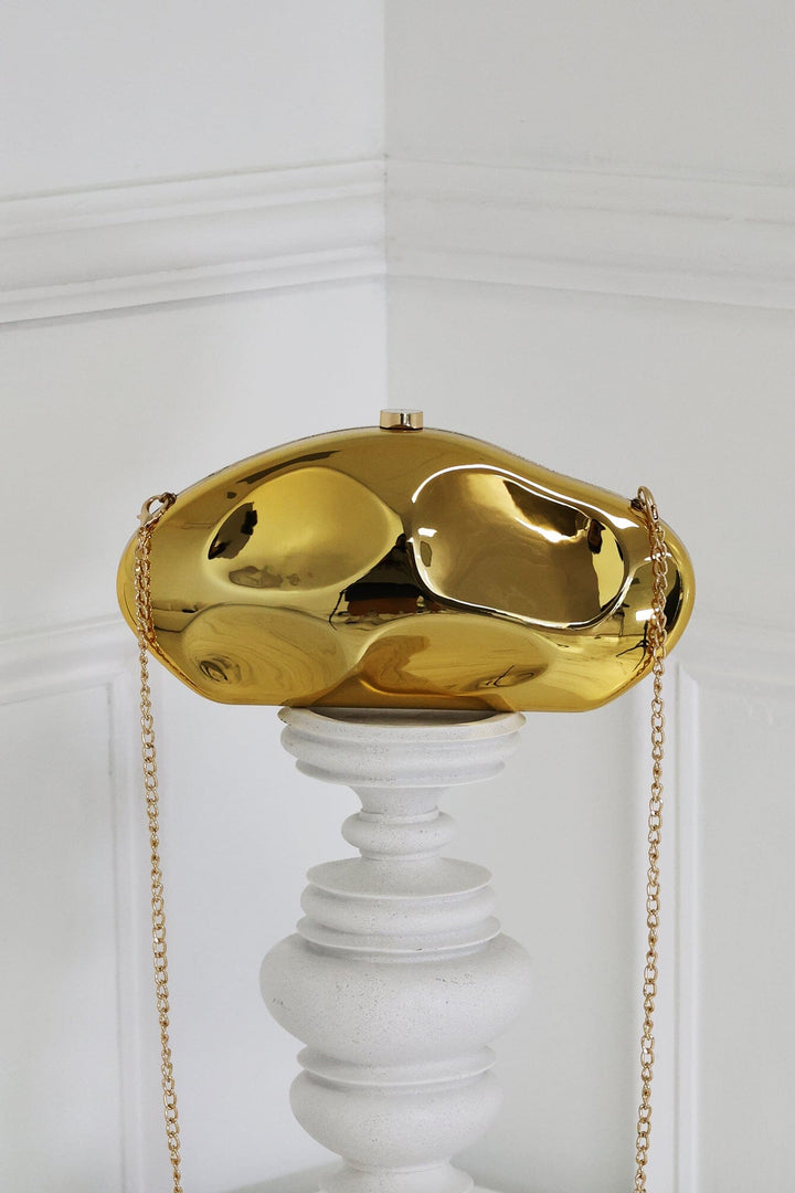 EDGE — gold mirror-plated mini clutch displayed on a pedestal, front view flat lay