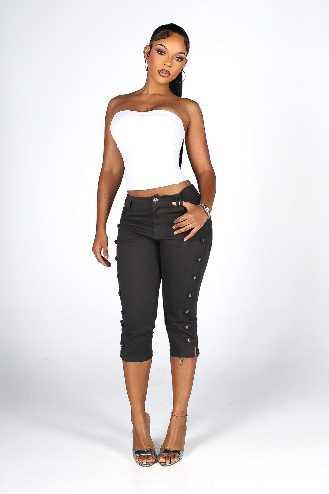 High rise capri denim pants with rows of decorative button trim running down each outer leg seam