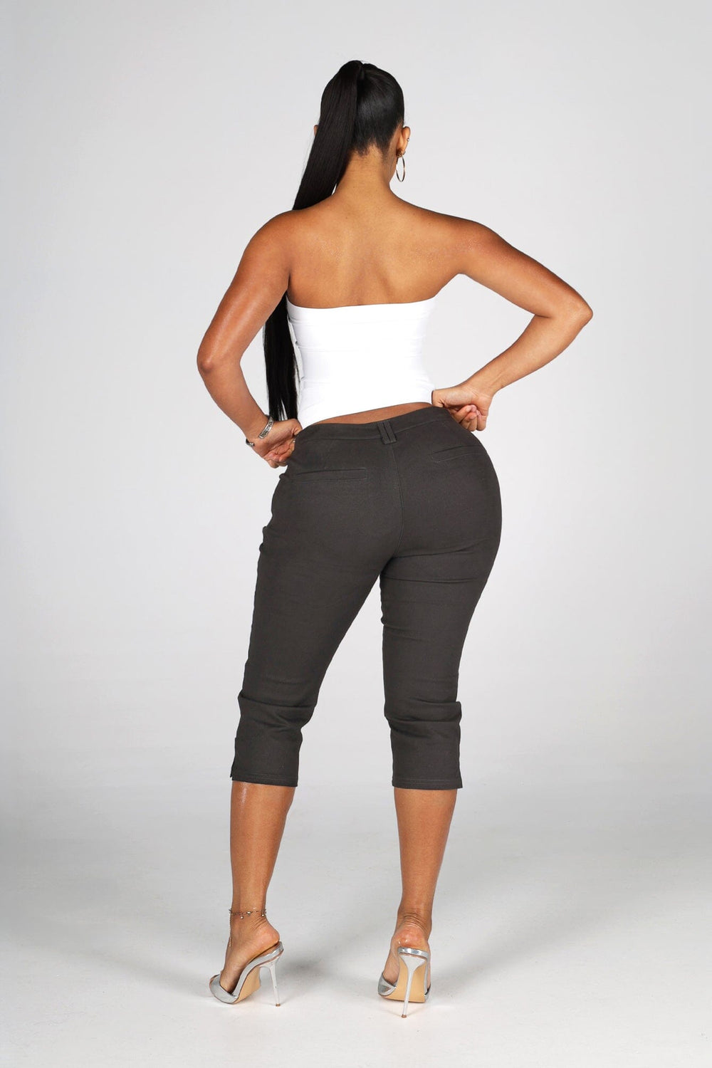 High rise capri denim pants with rows of decorative button trim running down each outer leg seam