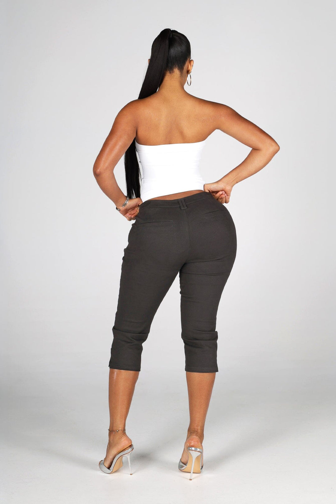 High rise capri denim pants with rows of decorative button trim running down each outer leg seam