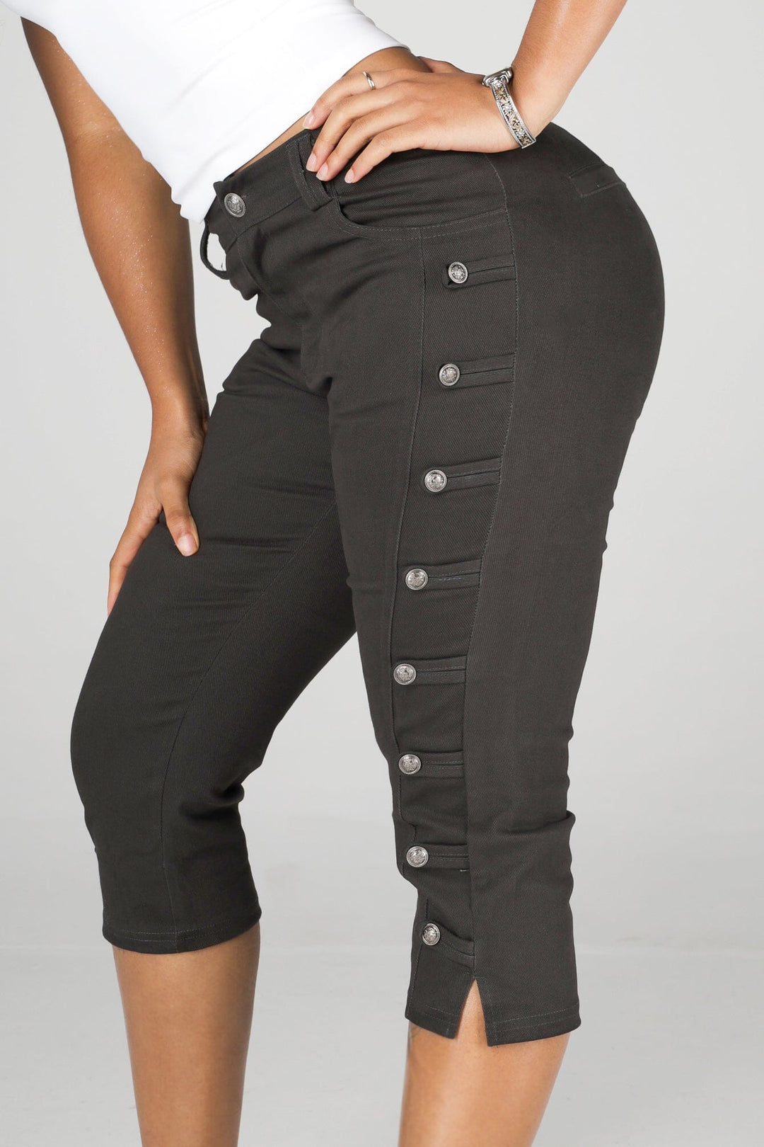 High rise capri denim pants with rows of decorative button trim running down each outer leg seam