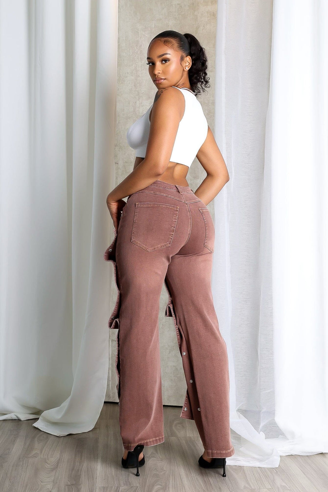 High waist wide leg jeans featuring multiple overlapping fabric flaps with metallic snap buttons