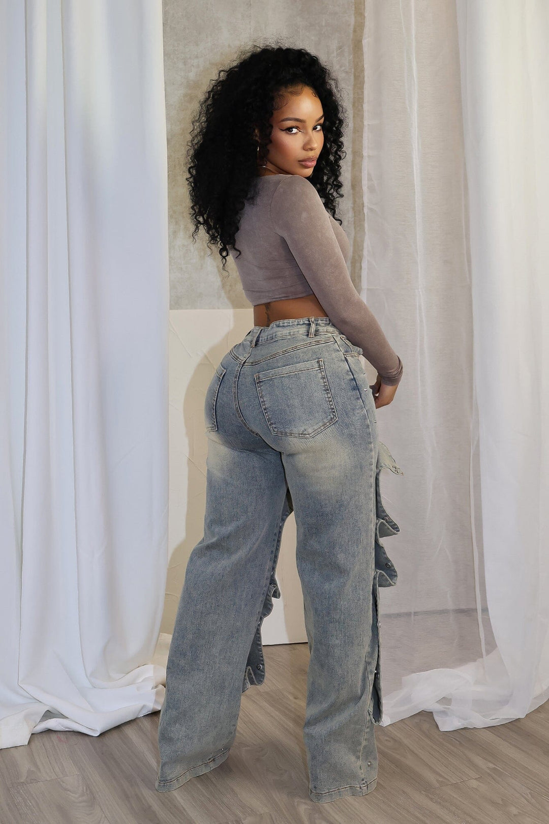 High waist wide leg jeans featuring multiple overlapping fabric flaps with metallic snap buttons