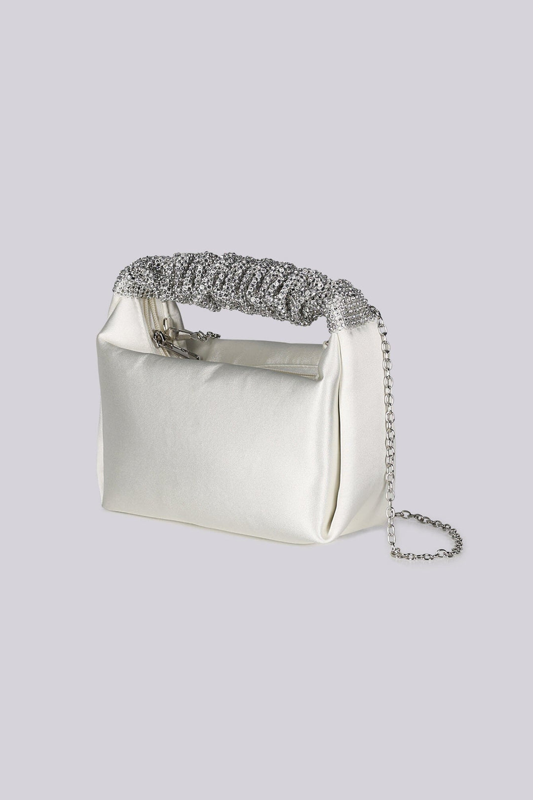 EDGE — ivory satin clutch with a crystal-embellished handle and chain strap, three-quarter side view flat lay