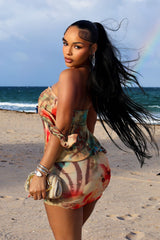 Abstract print tube mini dress featuring draped front detail with a metal accent and subtle volume through the waist