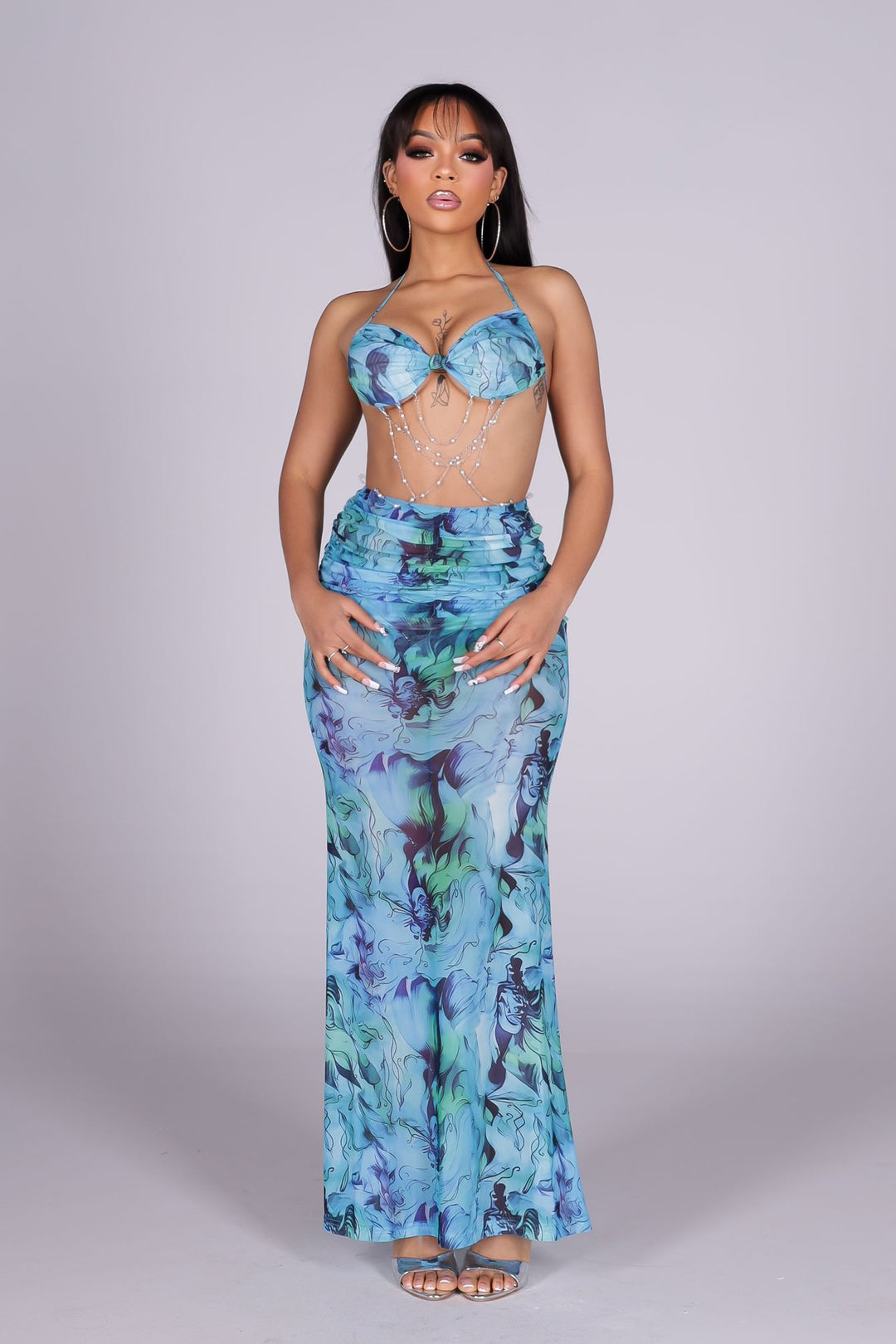 Halter bra top maxi dress with an open-back design
Mesh marble print with long shirring detail
Pearl chain detail at the front