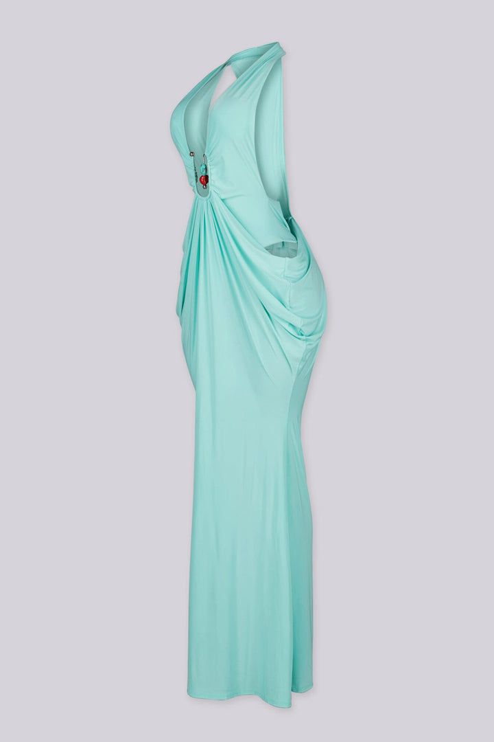 Deep plunging V front halter neck dress featuring bold side cut out at the midriff with U ring hardware detail at center front, Fitted through the hip with draped ruching that pools into the skirt