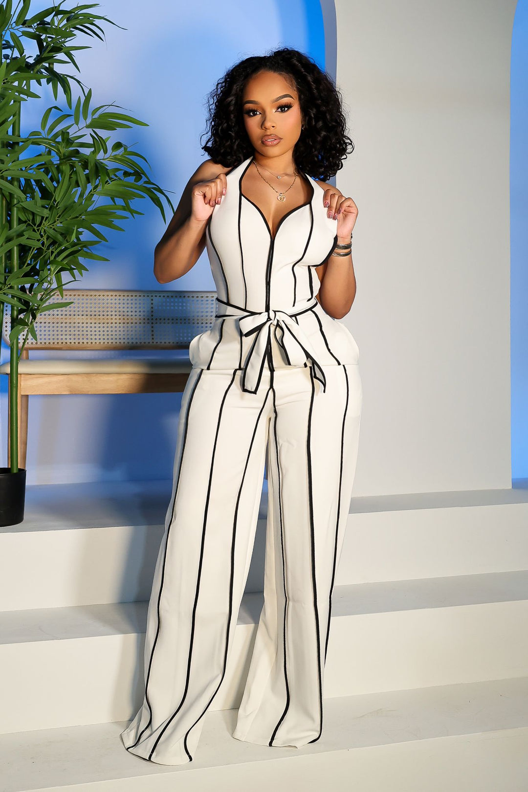 Wide leg halter jumpsuit with a plunging V neckline featuring waist tie