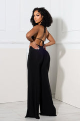 Wide leg halter jumpsuit with deep plunging cowl neck featuring a metal choker detail
