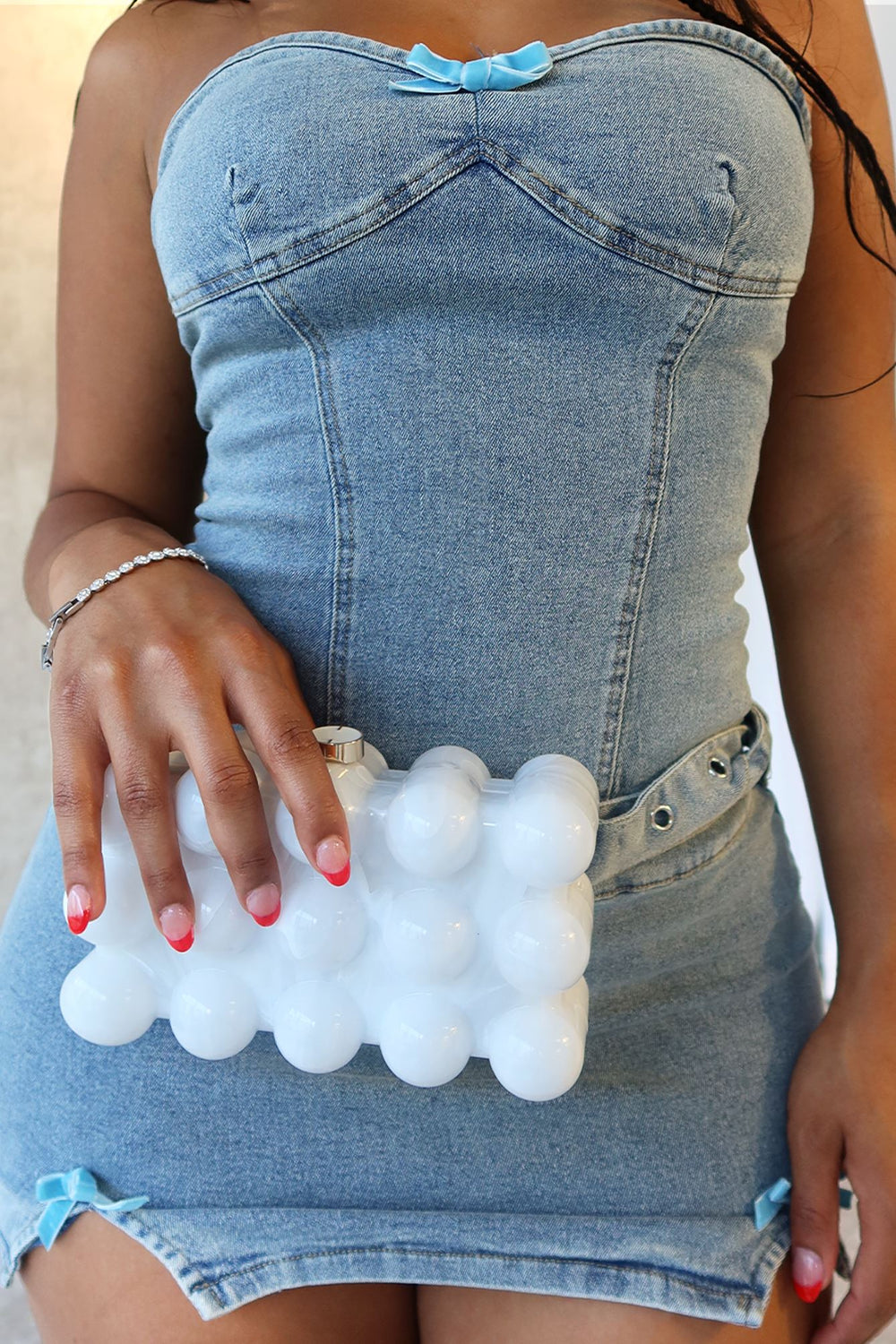 EDGE — pearl bubble-textured mini clutch held by a model in a denim dress