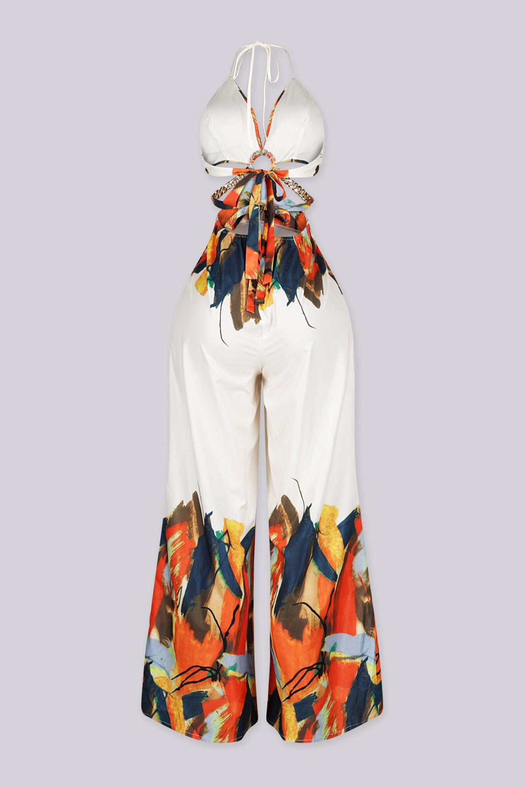 Halter neck jumpsuit featuring center O-ring with waist cut-outs, Edge gold chain straps connecting the front ring to the back ties
