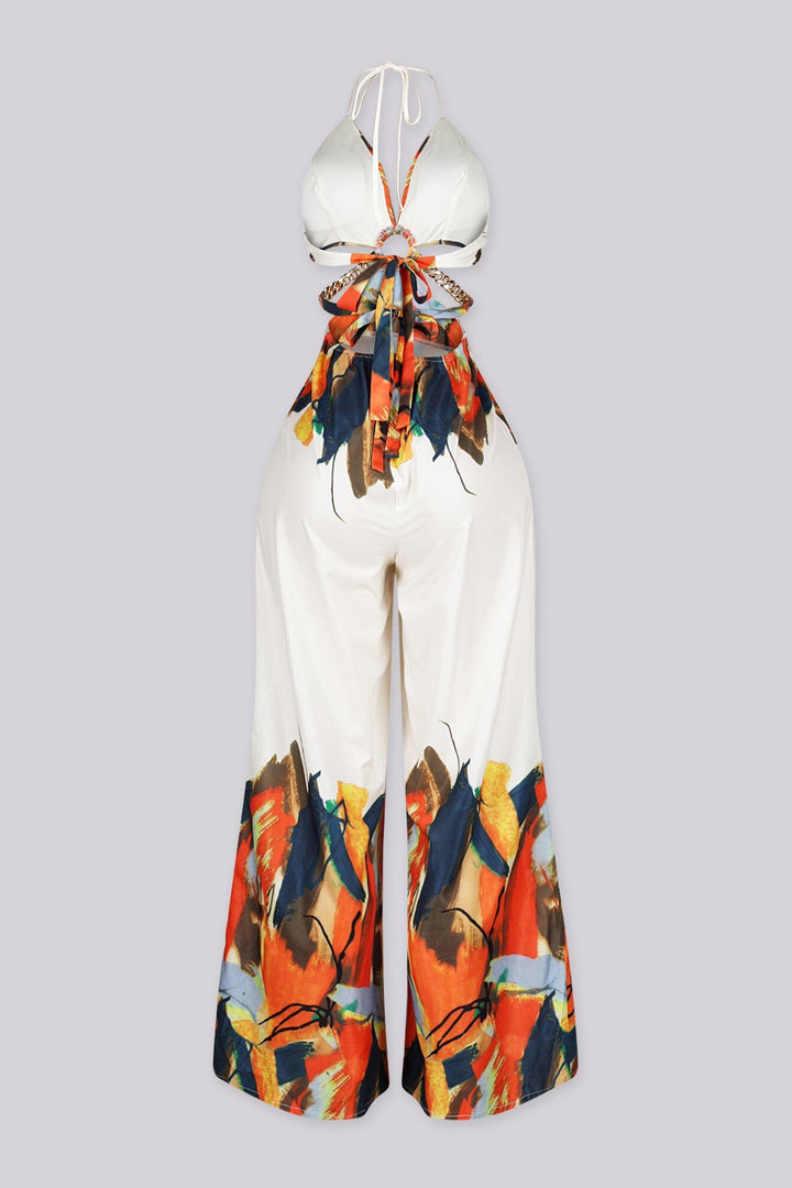 Halter neck jumpsuit featuring center O-ring with waist cut-outs, Edge gold chain straps connecting the front ring to the back ties