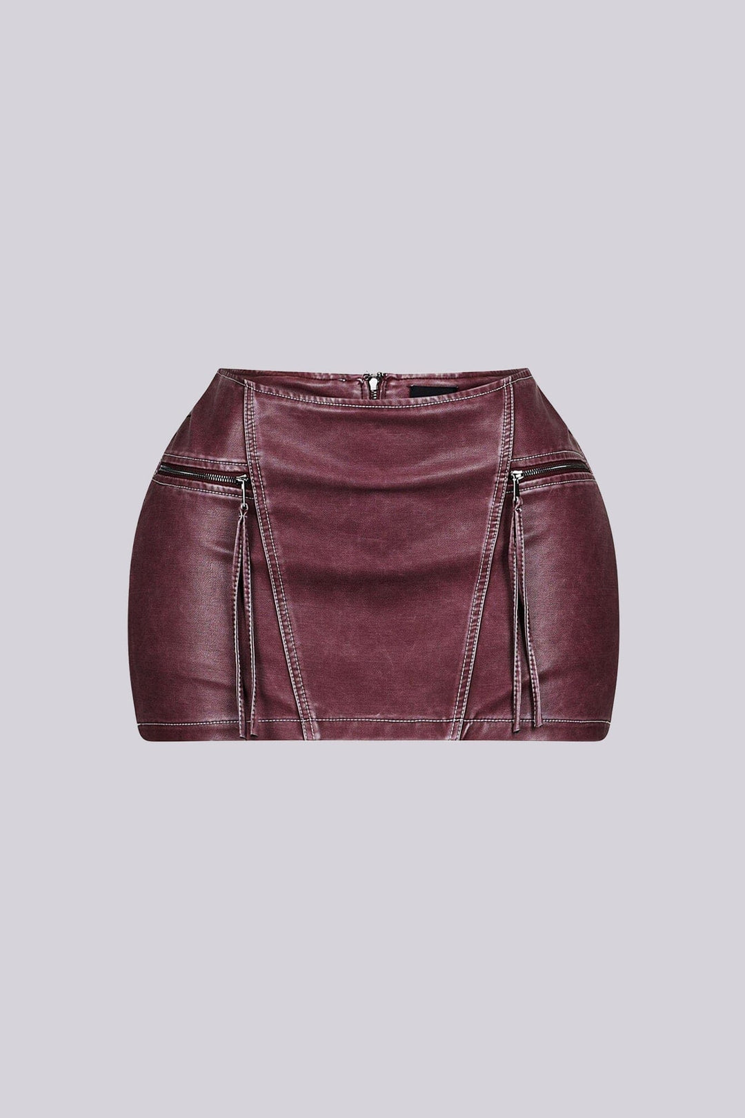 Faux leather low rise micro skirt with zip and tassel accenting on the sides featuring elasticized paneling at back