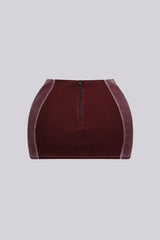 Faux leather low rise micro skirt with zip and tassel accenting on the sides featuring elasticized paneling at back