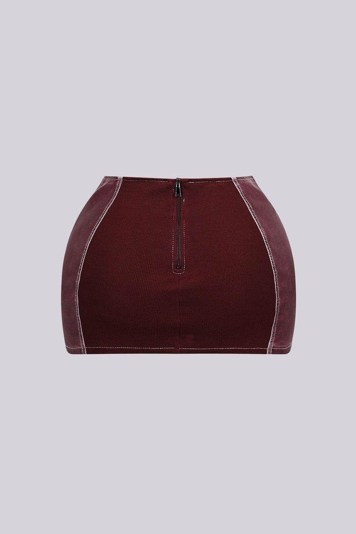 Faux leather low rise micro skirt with zip and tassel accenting on the sides featuring elasticized paneling at back