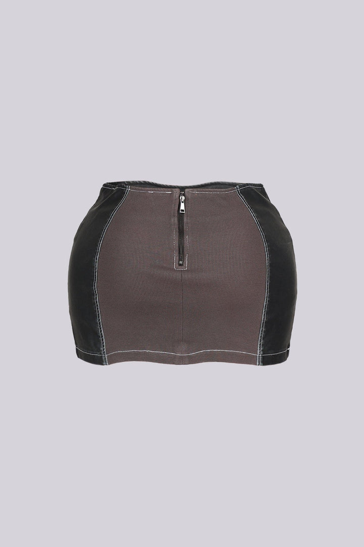 Faux leather low rise micro skirt with zip and tassel accenting on the sides featuring elasticized paneling at back