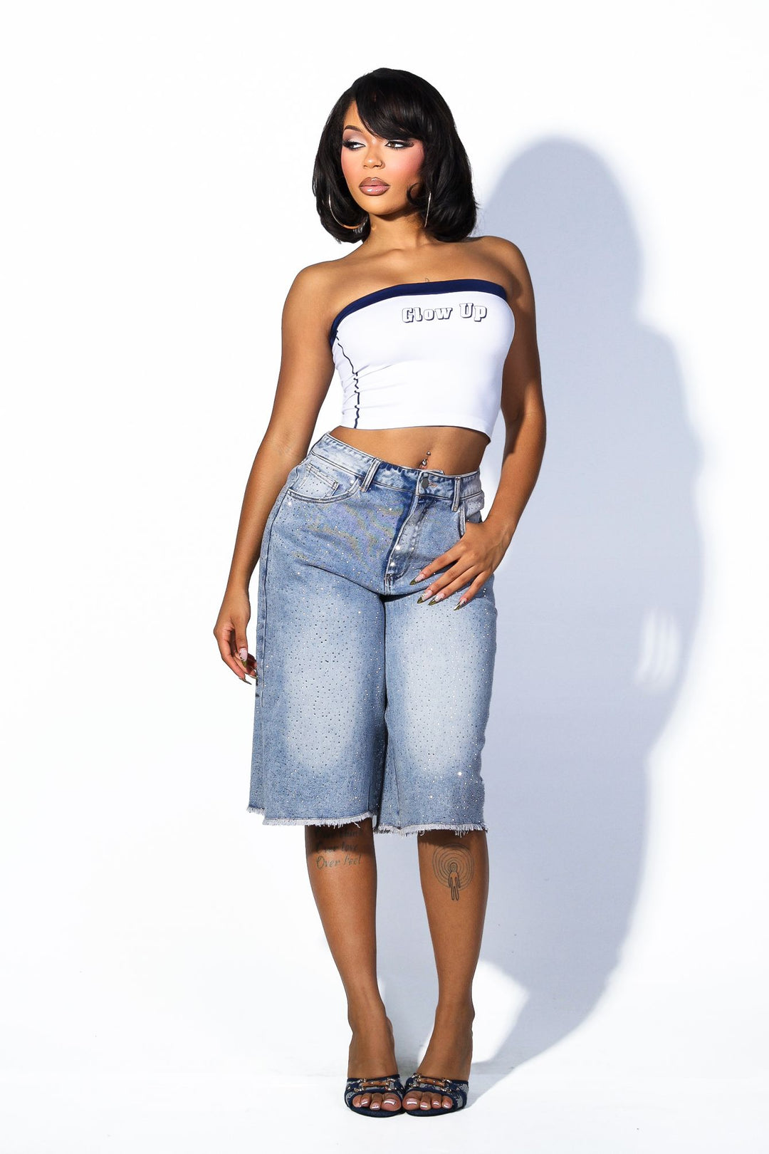 Wide denim bermuda shorts with frayed hem featuring rhinestone embellishments throughout&nbsp;