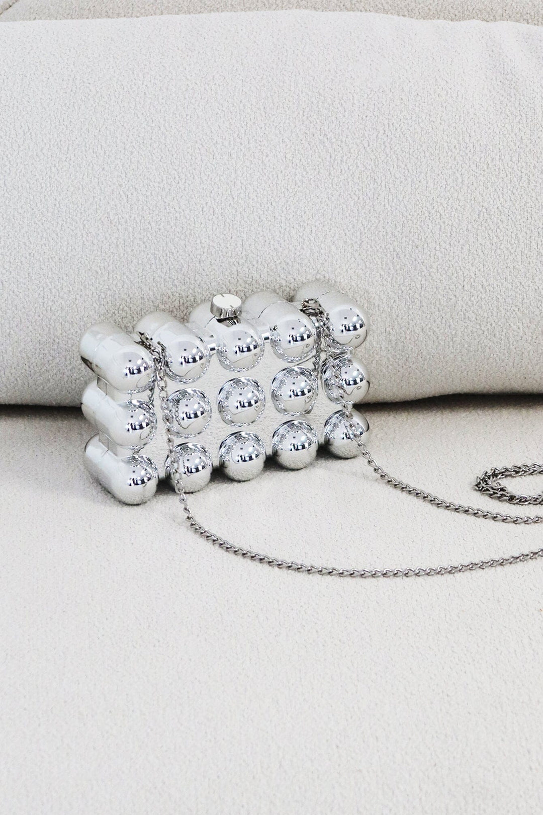 EDGE — silver bubble-textured mini clutch, angled flat lay