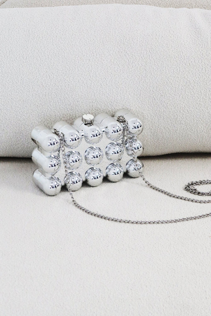 EDGE — silver bubble-textured mini clutch, angled flat lay