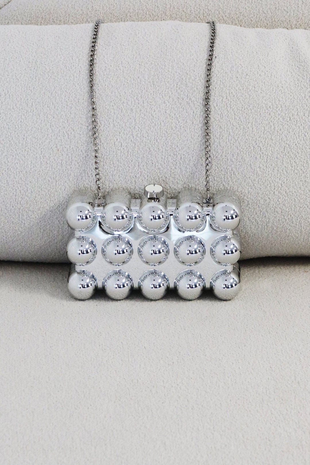 EDGE — silver bubble-textured mini clutch, front view flat lay