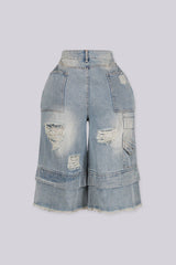 High rise wide leg bermuda denim shorts with distressed rips and frayed patches, back view
