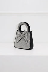 EDGE — black rhinestone bow-embellished top-handle mini clutch, side view flat lay