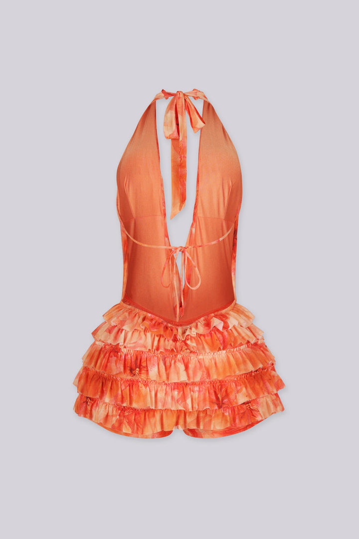 Orange floral romper featuring a halter top and tiered ruffle detailing,
Open back with self-tie closure