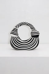 EDGE — black and white striped half-moon top-handle bag, front view flat lay