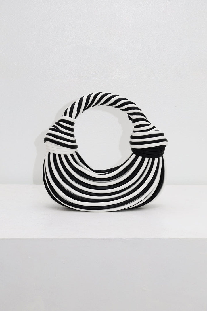 EDGE — black and white striped half-moon top-handle bag, front view flat lay