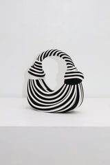 EDGE — black and white striped half-moon top-handle bag, alternate angle flat lay