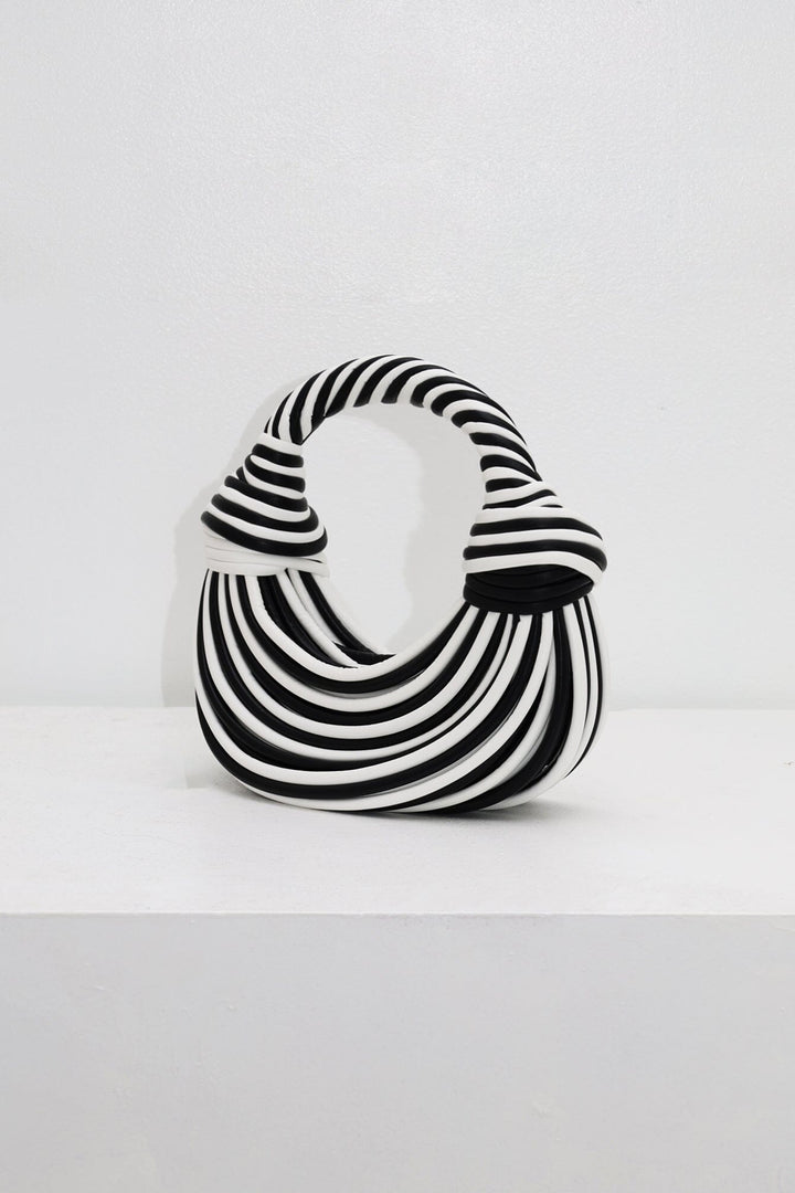 EDGE — black and white striped half-moon top-handle bag, alternate angle flat lay