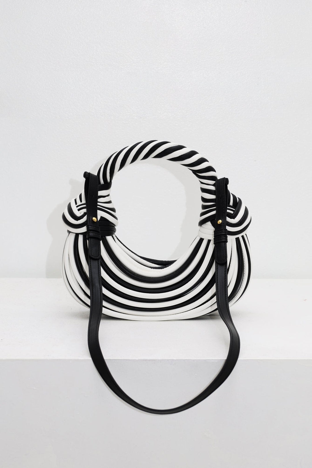 EDGE — black and white striped half-moon bag with detachable shoulder strap, flat lay